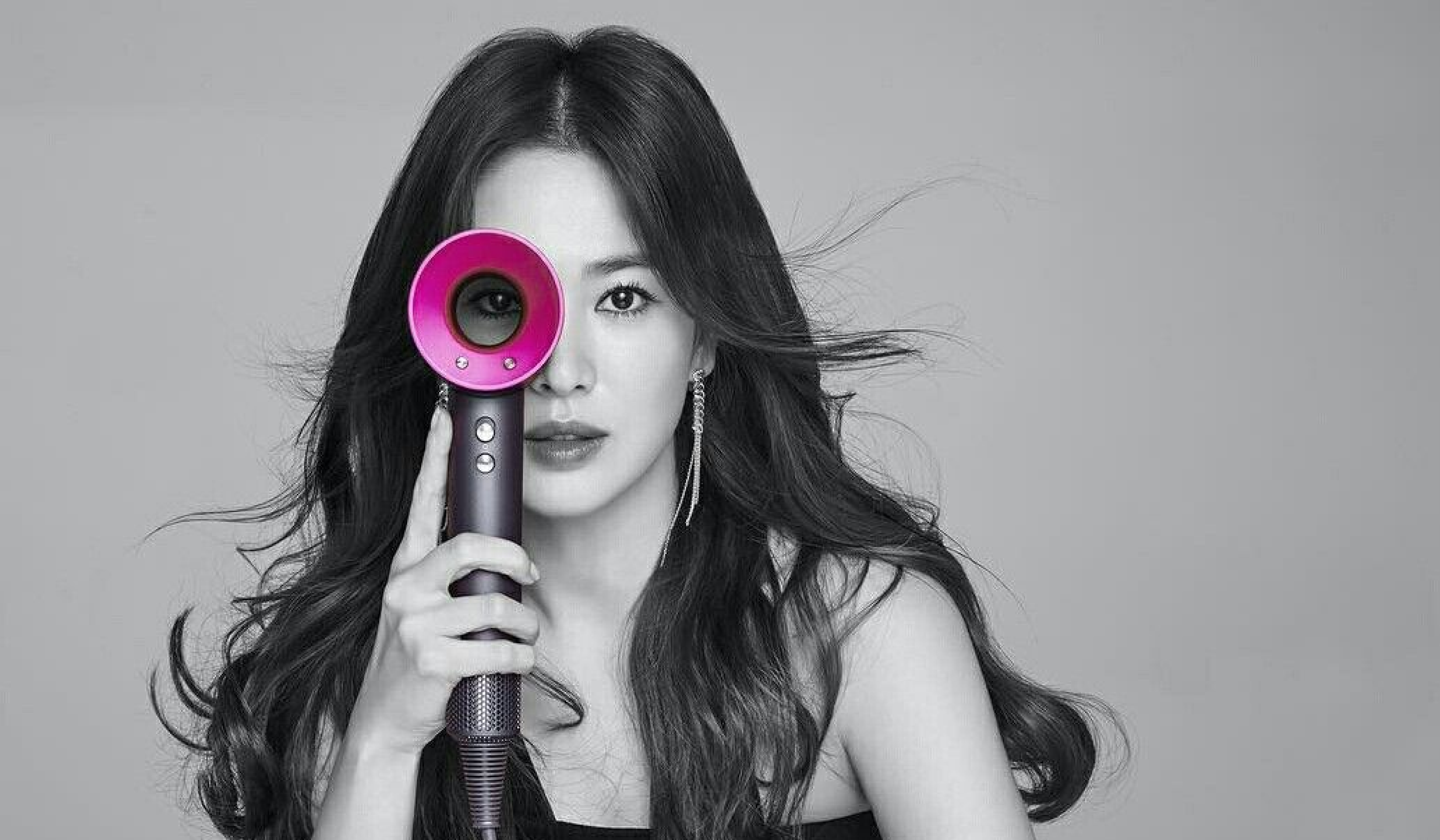 Woman holding a pink hairdryer